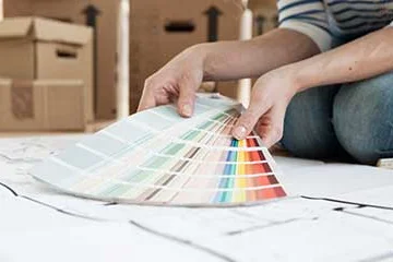 Person betrachtet einen Farbfächer.